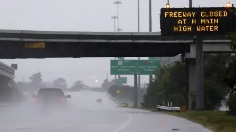 EPA A pick-up truck passes a warning sign on southbound Interstate 45 north of Houston, TX, as heavy rains from the remnants of Hurricane Harvey continue to flood many areas of the city (27 August 2017)