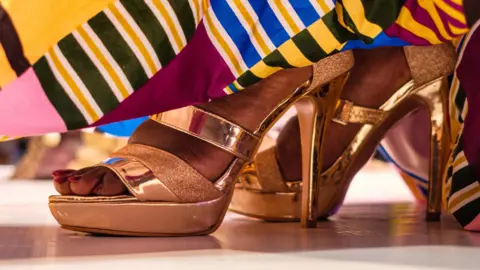 A contestant walks on a stage during the first edition of Miss Curvy Uganda in Kampala, Uganda, on April 26, 2019. -