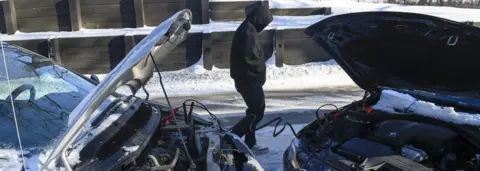 EPA Roshewn Harington of St. Paul, MN tries to start his car in the -30 degrees Fahrenheit (-35 degrees Celsius) weather that has made travel difficult in Minneapolis