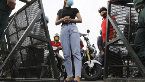 EPA A pedestrian stops in front of a police barrier on a street in Phnom Penh, Cambodia