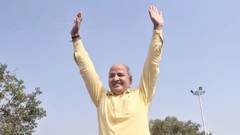 Getty Images Delhi Deputy Chief Minister Manish Sisodia waves to the supporters at Rajghat prior to leaving for the Central Bureau of Investigation (CBI) office for questioning in connection with the liquor policy case, on February 26, 2023 in New Delhi, India. Sisodia and others face corruption allegations linked to a liquor sale policy in the national capital.