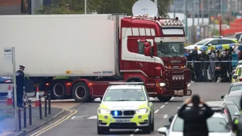 PA Media Lorry container being moved under police escort