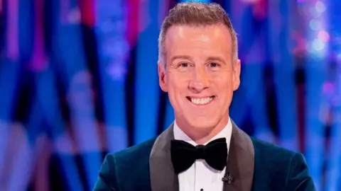 BBC/Guy Levy Anton du Beke, wearing a teal velvet jacket, black bow tie and white shirt, grins at the camera