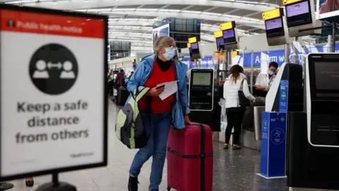 Reuters A passenger walks with her luggage at the Terminal 5 departures area at Heathrow Airport