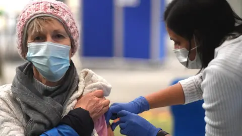 EPA A woman receives the AstraZeneca Covid19 vaccine at an NHS vaccination centre in Ealing, west London