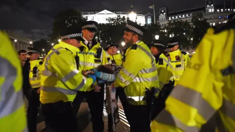 PA Media Police remove an Extinction Rebellion protester from Trafalgar Square in central London.