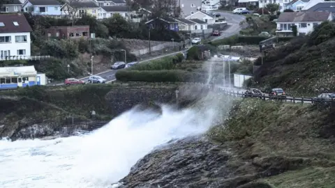 Ashley Williams Waves crash over the road at Mumbles, Swansea Bay