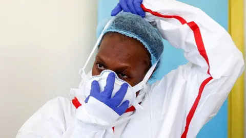 Reuters A woman putting on a mask