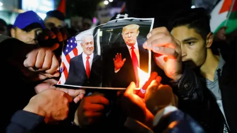 AFP Palestinian protesters burn pictures of US President Donald Trump and Israel's Prime Minister Benjamin Netanyahu during a demonstration in the West Bank city of Ramallah