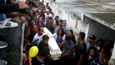 Reuters Relatives and friends watch as Ágatha's casket is carried at her funeral