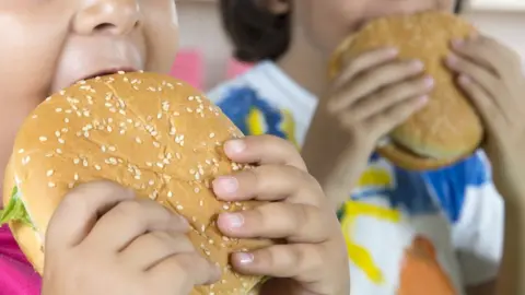 Getty Images Two children eat burgers