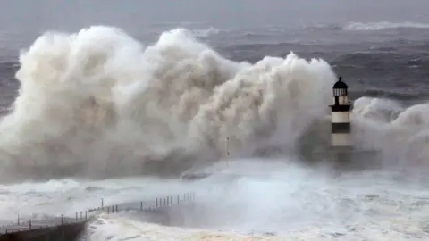 Reuters Huge waves crash against the pier wall at Seaham Lighthouse during Storm Arwen, in Seaham, County Durham on 27 November