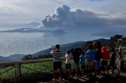 Reuters Residents look at the erupting Taal Volcano in Tagaytay City, Philippines, January 13