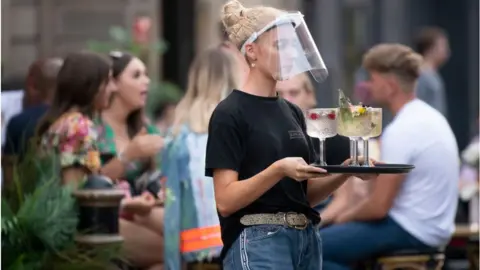 Getty Images Waitress wearing PPE