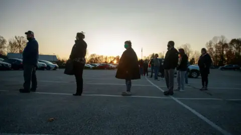 LightRocket via Getty Images) Voters line up on Election Day 2020 to cast their ballots at St. John the Apostle Catholic Church in Indiana