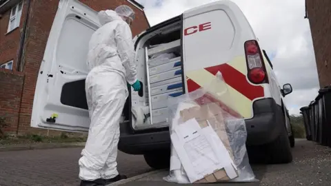 Essex Police Police forensic officer loading evidence into a van