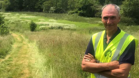 Justin Guy Wildlife officer Howard Yardy in front of the Naish Hill meadow between the Wilts & Berks Canal and the River