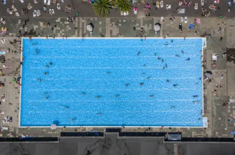 Jason Hawkes People swimming in the acrylic Sky Pool at Embassy Gardens in Nine Elms