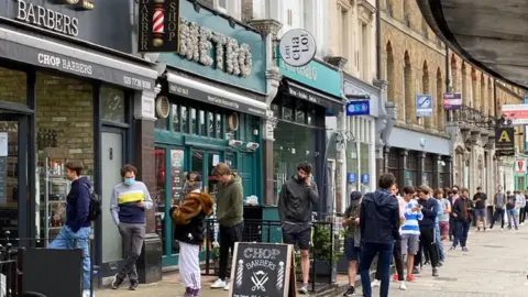 Martin Duncan Long queues outside a barbers in Clapham, south London