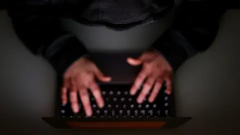 PA Media Hands typing on a keyboard, shot from above