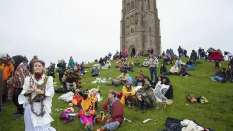 EPA Revellers gather to celebrate the summer solstice on Glastonbury Tor, Somerset,