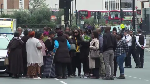 Family members and friends gathering in a group of more than 20 people on Wellesley Road.