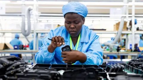 AFP Ugandan factory workers assemble mobile phone cases