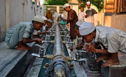 Getty Images Indian Muslim children are seen performing ablutions before offering prayers in a mosque during the first day of the holy fasting month of Ramadan in Patiala district of Punjab.