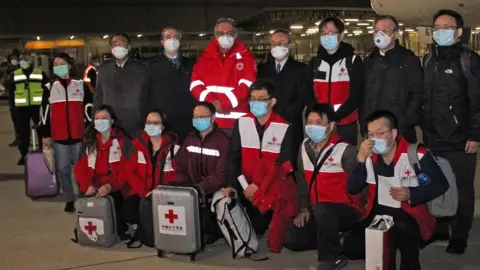 AFP Chinese medics posing for a group photo after landing on a China Eastern flight on March 13 at Rome"s Fiumicino international airport from Shanghai, bringing medical aid to help fight the new coronavirus in Italy