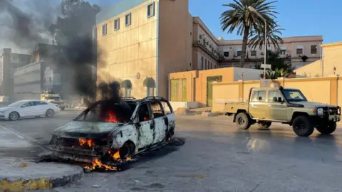 Getty Images Damaged vehicles in Tripoli