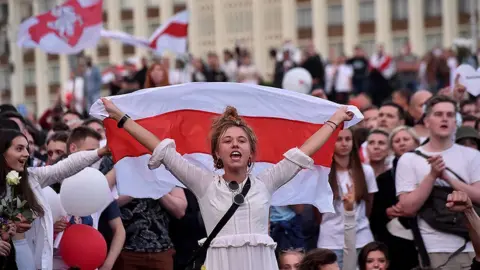 Getty Images A woman shouts as she holds a Belarus flag