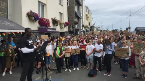 BBC Protesters gathered in front of person speaking