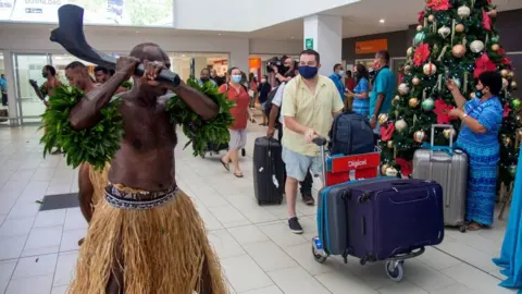 Getty Images International arrivals at Fiji's main airport are welcomed by traditional dancers in December 2021