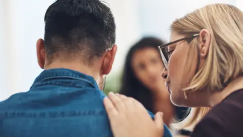 Getty Images Woman reassuring a depressed man