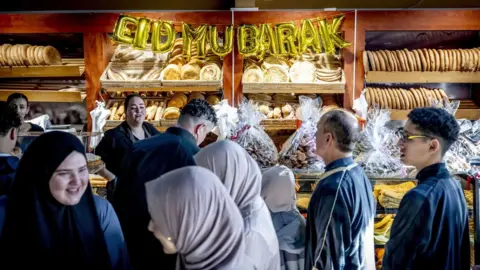 EPA People inside a bakery, with a sign saying 'Eid Mubarak' in Rotterdam, the Netherlands