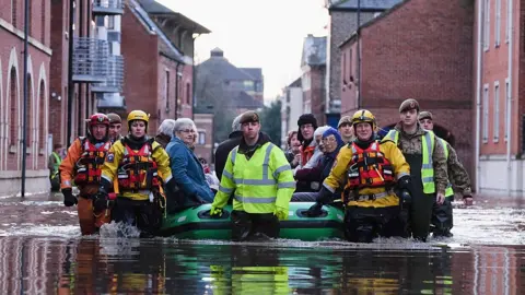 Getty Images Members of Cleveland Mountain Rescue and soldiers from 2 Battalion The Duke of Lancasters Regiment assist members of the public as they are evacuated from the Queens Hotel in York