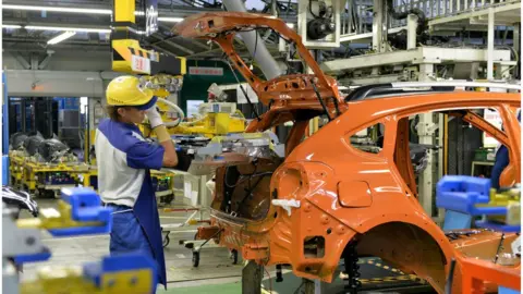 AFP A worker installs batteries in a Subaru vehicle at a Japanese manufacturing plant