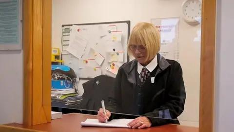 Gill Miles behind the lost and found property desk of Transport for Wales in Newport