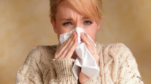 Getty Images Woman blowing her nose