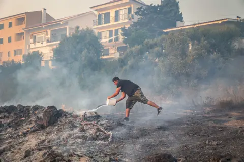 Manuel de Almeida / EPA A man battles the flames in Alto do Alvide, Cascais, Portugal