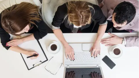 Getty Images Overhead shot two men and a women at work