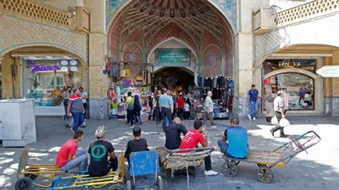 Getty Images Iranians wait outside Tehran's ancient Grand Bazaar in Tehran on 28 July 2018