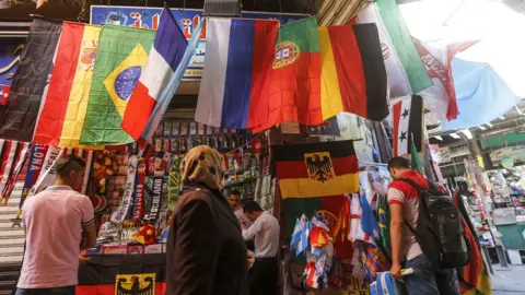 AFP A shop in the old city of Damascus selling flags of the World Cup finals teams