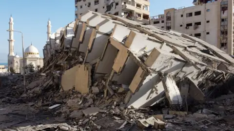 Reuters Remains of the Hanadi tower in Gaza City following its destruction in an Israeli air strike (12 May 2021)