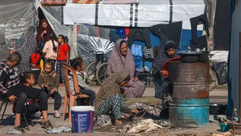 MOHAMMED ABED/Getty images Displaced Palestinians cook in a makeshift outdoor kitchen near their tent in Rafah in the southern Gaza Strip