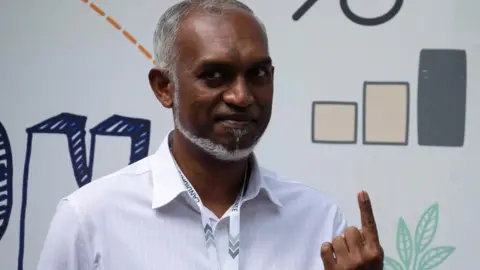 Reuters Mohamed Muizzu posed for cameras after casting his vote at a polling station in Male