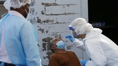 Boston Globe/Getty Images A nurse a coronavirus test at a COVID-19 testing site in Boston on Oct. 22, 2020.