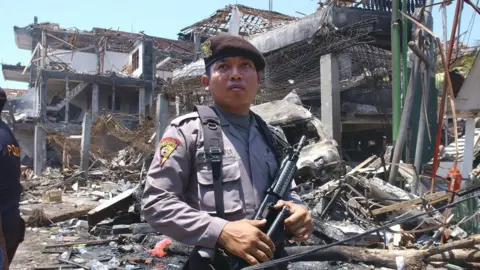 Getty Images An armed Indonesian policeman guards what remains of a nightclub in the aftermath of the Bali bombing in October 2002.