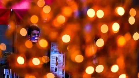 Getty Images A waiter in Miami wears a mask during the dinner rush