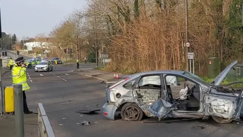 Kent Police A significantly damaged light blue Ford Focus car blocks a